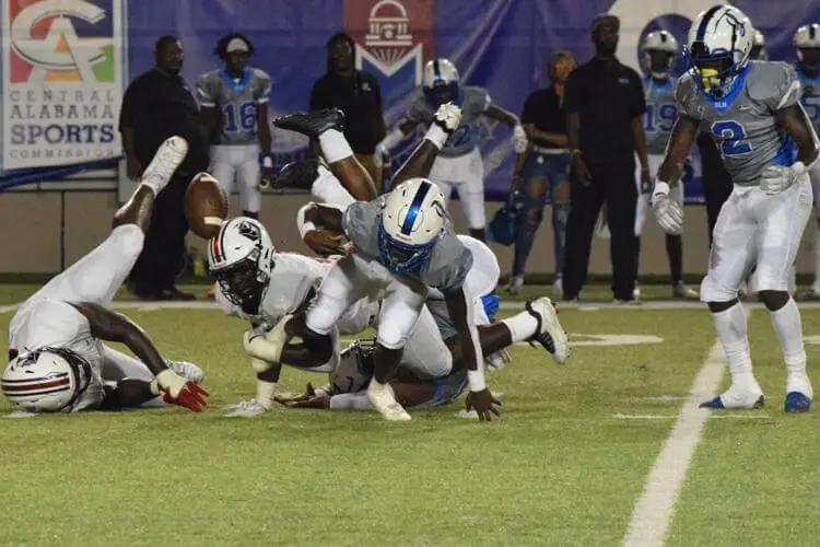 Lanier Quartback Braylon James loses handle on the ball after being hit by Pike Road's Jaylan Jarrett, Malik Blocton.